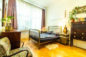a bedroom with a bed and a chair and a window at Family place in Old town/center in Liberec