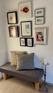 Un banco en una habitación con cuadros en la pared. en LAUSANNE PULLY sunny apartment on lakeside street and direct bus to Lausanne train station, en Pully