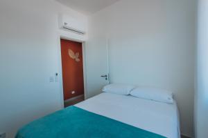 a bedroom with a white bed and a red door at Apto completo e charmoso para curtir a praia in Itapoa +35 photos