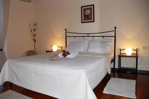 a bedroom with a large white bed with two lamps at THEODORA in Nafplio