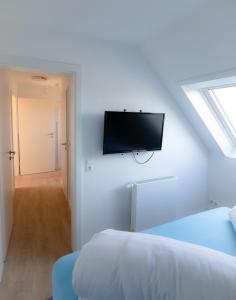 a bedroom with a bed and a tv on the wall at Seemöwe in Friedrichsschleuse