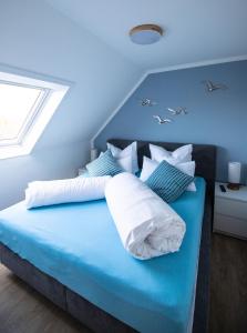 a blue bed with white pillows and birds on it at Seemöwe in Friedrichsschleuse