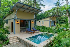 une villa avec piscine devant une maison dans l'établissement Gardenia Springs - La Finca Buritaca, à Buritaca