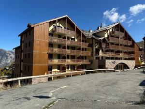 a building with a parking lot in front of it at Risoul duplex 48m2 avec piscine et sauna in Risoul