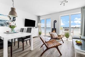 a living room with a white table and chairs at Ferienhaus Seestern Olpenitz in Olpenitzdorf