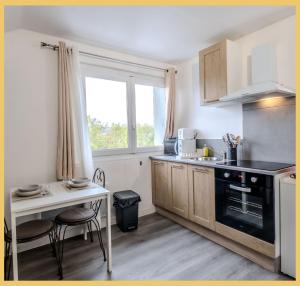 eine Küche mit Spüle und Tisch mit Stühlen in der Unterkunft Chez Julien I Studio I Etrembières in Étrembières