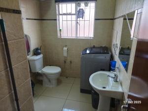 a small bathroom with a toilet and a sink at Royal Inn - Fully Furnished Self-Catering Apartments in Lenasia
