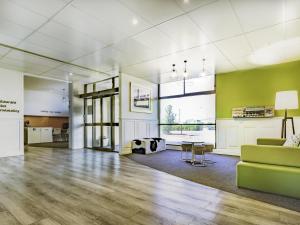 a living room with a couch and a table at ibis Styles Mt Isa Verona in Mount Isa