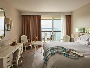 a hotel room with a bed and a table and chairs at Sofitel Golfe d'Ajaccio Thalassa Sea & Spa in Ajaccio