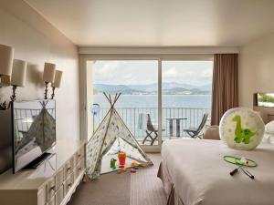 a hotel room with a bed and a view of the ocean at Sofitel Golfe d'Ajaccio Thalassa Sea & Spa in Ajaccio +199 photos
