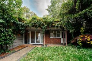 une maison en briques avec des arbres devant elle dans l'établissement Bright & Comfy 3-BR House in Feltham and a Separate Studio - Sleeps 11!, à New Bedfont