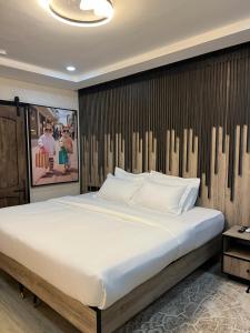 a bedroom with a large bed with a wooden wall at The Westbury Inn in Abuja