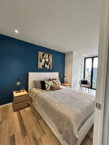 a bedroom with a large bed with a blue wall at Apartamento 2 Habitaciones, Edificio Airali, Zona 10, Florencia in Estación Pamplona