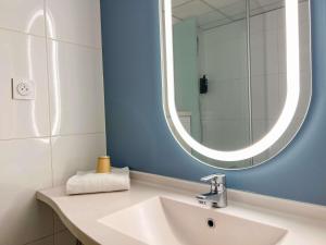a bathroom with a white sink and a mirror at ibis Nîmes Ouest - A9 in Nîmes