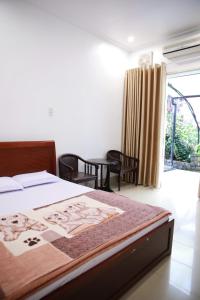 ein Schlafzimmer mit einem Bett mit einem Gemälde darauf in der Unterkunft Khách sạn Bảo Lộc Garden in Bảo Lộc