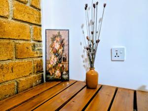 a vase sitting on a table next to a brick wall at purple villa in Mirissa