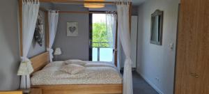 a bedroom with a canopy bed with a window at Maison d'Hôtes Sainte Hune Chambres et appartements in Hunawihr
