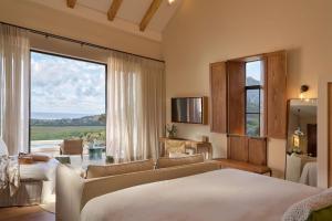 a bedroom with a couch and a large window at The Alexander Estate in Good Hope