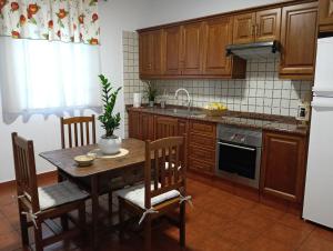 a kitchen with wooden cabinets and a table with a plant on it at La Viñita in El Paso
