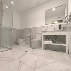 a bathroom with a toilet and a sink and a shower at Stella Braga Aparthotel in Braga