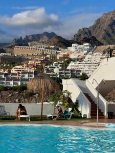 twee personen op stoelen naast een zwembad bij El Sueño in Adeje