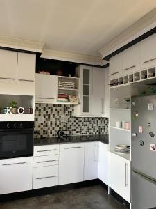 a kitchen with white cabinets and a refrigerator at Lee Place in Maseru