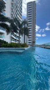 a swimming pool in front of two tall buildings at Flat aconchegante 1307 in Fortaleza