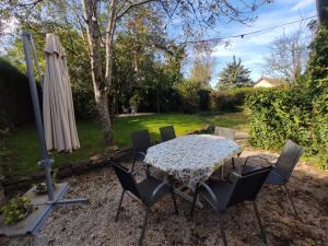 un tavolo con sedie e un ombrellone in un cortile di Le Lion de Venise a Saulon-la-Rue