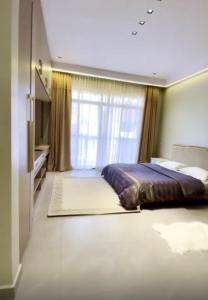 Un dormitorio con una cama y una ventana grande. en Lacasa Homes, en Kampala