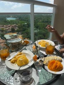 a table with plates of food on a table with a view at Flat aconchegante 1307 in Fortaleza +12 photos