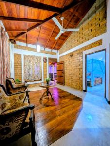 a living room with a ceiling fan and a brick wall at purple villa in Mirissa