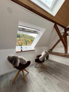 twee stoelen in een kamer met een raam bij Haus am Bach in Schleiden