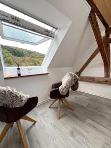 een woonkamer met 2 stoelen en een raam bij Haus am Bach in Schleiden +11 foto's