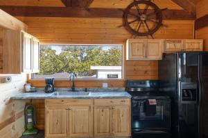a kitchen with a sink and a black refrigerator at Lighthouse Lodge Pool House - Lakefront studio on the pool deck in Kimberling City