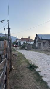 un camino de tierra con una valla y una casa en El Edén, en El Mollar