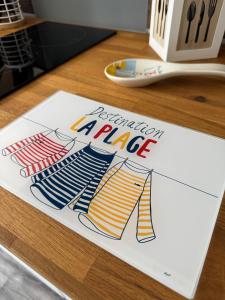 ein Stück Papier auf einem Schreibtisch mit der Aufschrift „Geburtstagsaffe“ in der Unterkunft Appartement proche de la plage in Gravelines