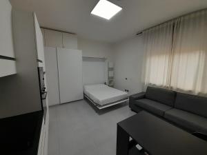 ein Wohnzimmer mit Sofa und Bett in der Unterkunft Zambo's in Agrate Brianza