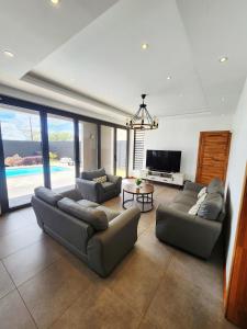 a living room with two couches and a television at VLAP Residence in Terre Rouge