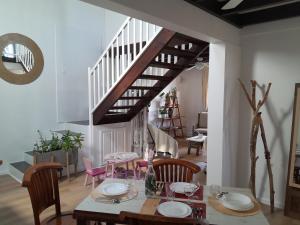 a dining room with a table and chairs and a staircase at L'Empreinte by LONBRAZ VOLKAN in Saint-Philippe