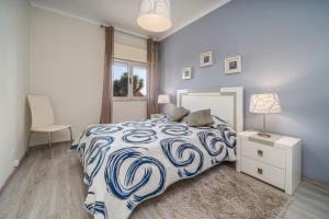 a bedroom with a bed with a blue and white comforter at Beach Apartment On The Beach in Praia da Rocha