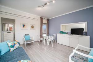 a living room with a couch and a table with chairs at Beach Apartment On The Beach in Praia da Rocha