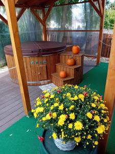 a hot tub and flowers in a gazebo at Békafütty Vendégház in Ráckeve