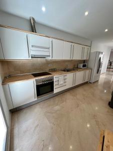 een keuken met witte kasten en roestvrijstalen apparaten bij Apartamento Centro con Aparcamiento in Santa Cruz de Tenerife