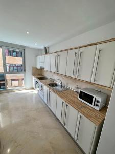een keuken met witte kasten en een magnetron bij Apartamento Centro con Aparcamiento in Santa Cruz de Tenerife
