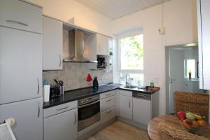 una cucina con mobili bianchi e un tavolo di Feel Meer a Schausende