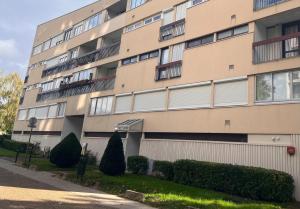 a large apartment building with bushes in front of it at Votre studio exceptionnel à Compiègne in Compiègne