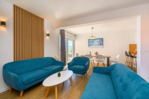 a living room with two blue couches and a table at Villa Zvonimir in Sreser