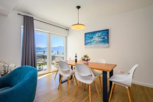 a dining room with a table and chairs and a blue couch at Villa Zvonimir in Sreser