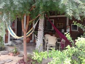 a patio with a table and chairs under a tree at Brisa da Serra Pousada EM SOBRAL-CE in Sobral