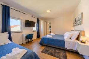 a hotel room with two beds and a desk at Villa Zvonimir in Sreser